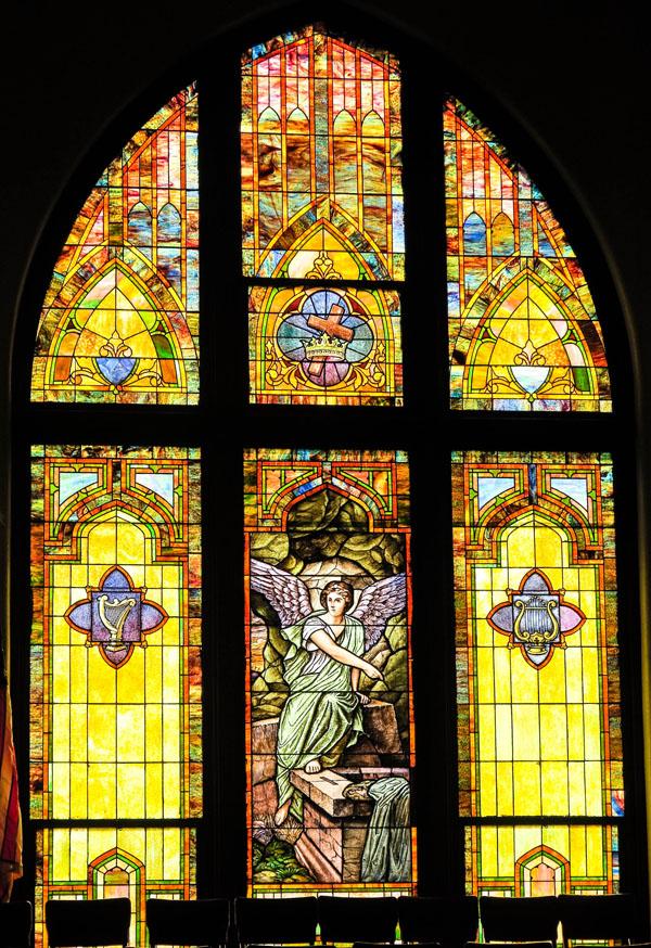 A vibrant stained glass window depicting a religious scene.